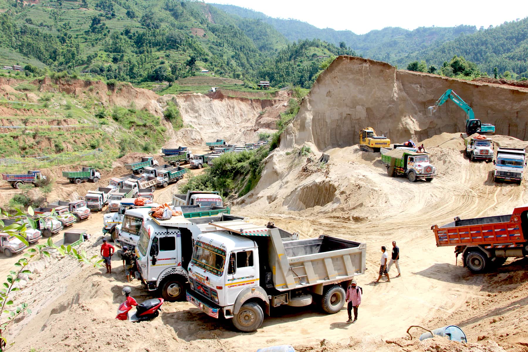 गजुरी गाउँपालिकाको पिडा धारापानीमा कच्चा बालुवा भर्नको लागि राखिएका टिपरहरू । युनिक खनिज प्रशोधन केन्द्रको लाइसेन्स प्रयोग गरेर स्थानीयको जग्गामा चलाइएको बालुवा खानी हो । तस्वीरहरू : मनिष दुव